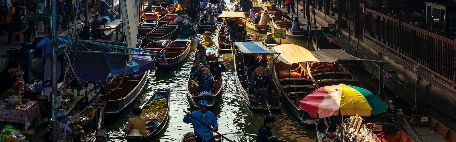 An overview of a floating market with people selling and buying things 