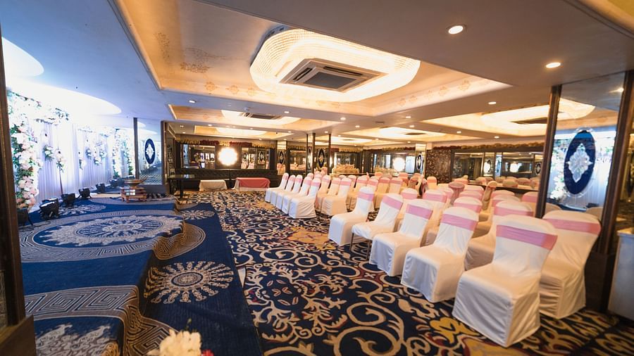 Magadh showcasing blue patterned flooring, neatly arranged tables and chairs, and contemporary lighting.