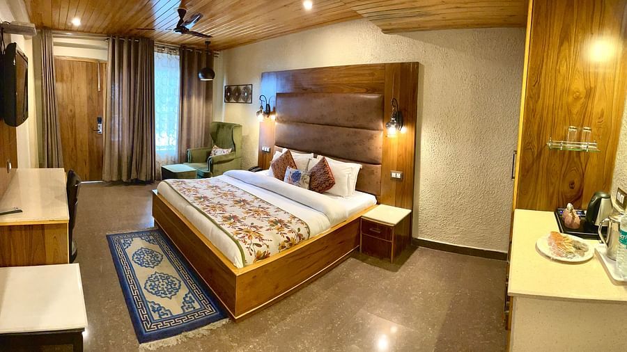 A side view of a bed in a well-furnished room | Mongas Hotel & Resort, Dalhousie