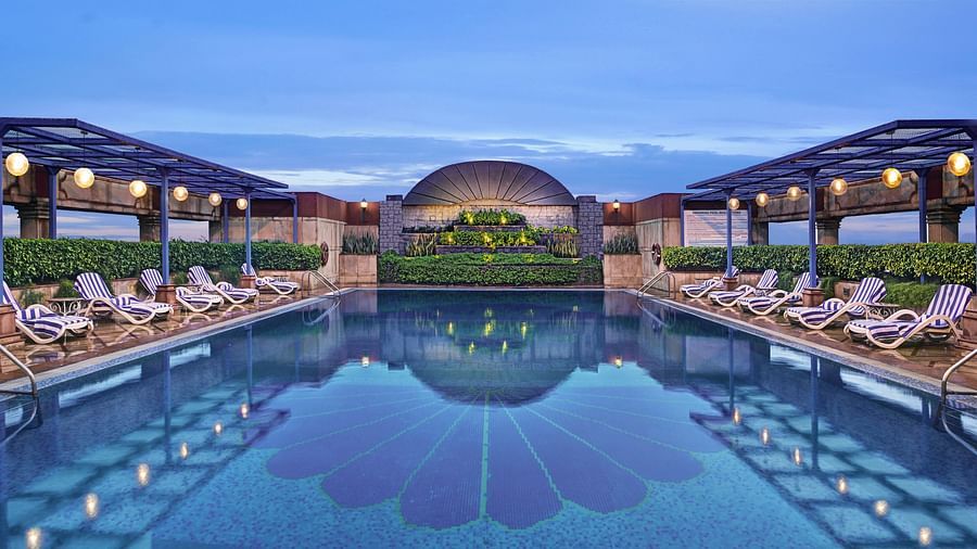 swimming pool surrounded by the lounge chairs - hotel spas in DLF Phase-1 in Gurgaon