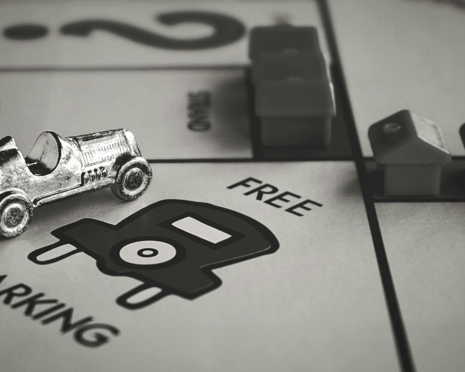 A close-up shot of a Monopoly board game showing the 'Free Parking' space with game pieces.