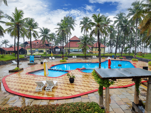 the pool surrounded by palm trees at MGM Beach Resorts, Muthukadu