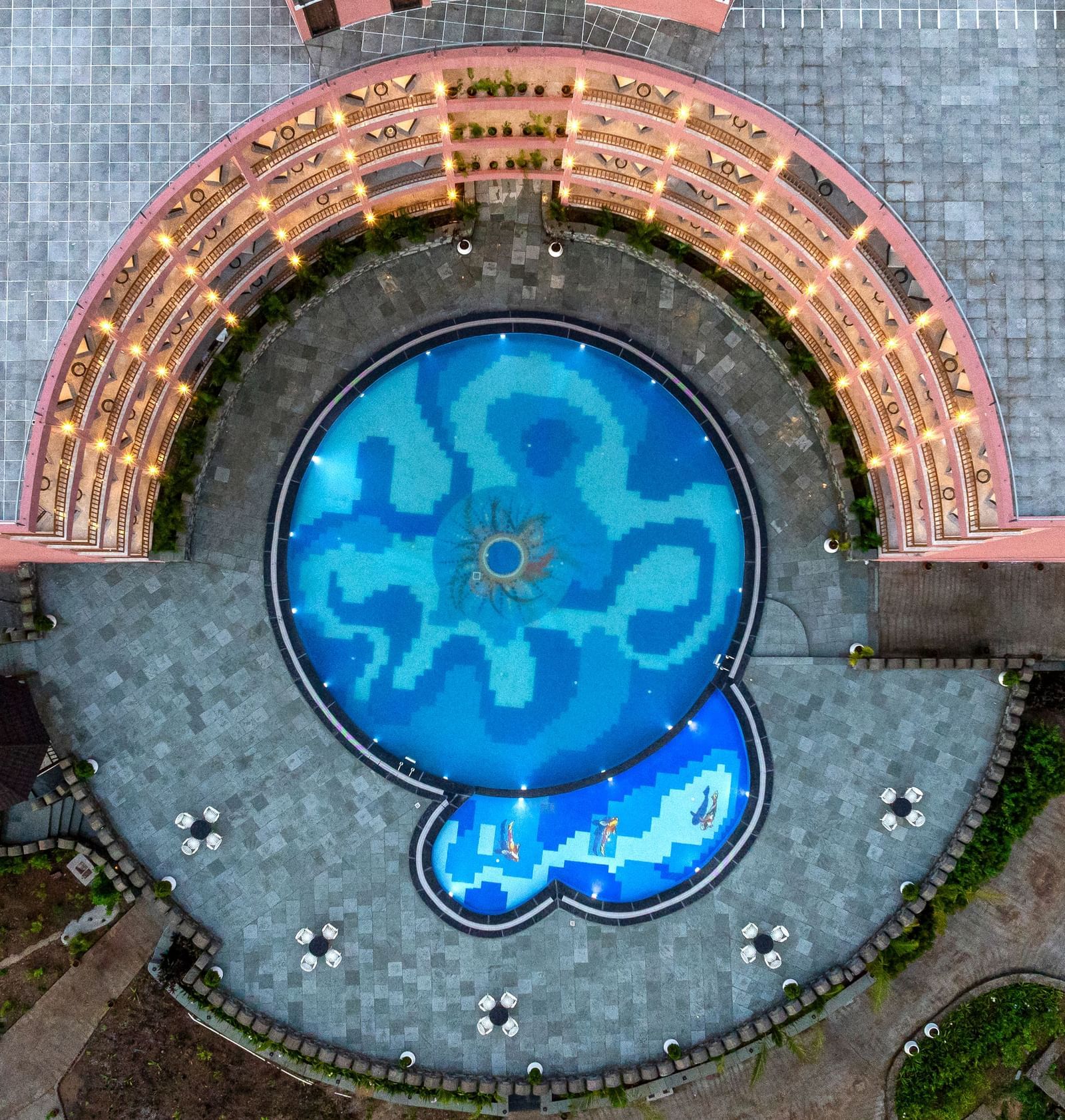 An aerial view of the Osian Valley Resort & Spa showing a central blue-tiled swimming pool partially surrounded by a building.