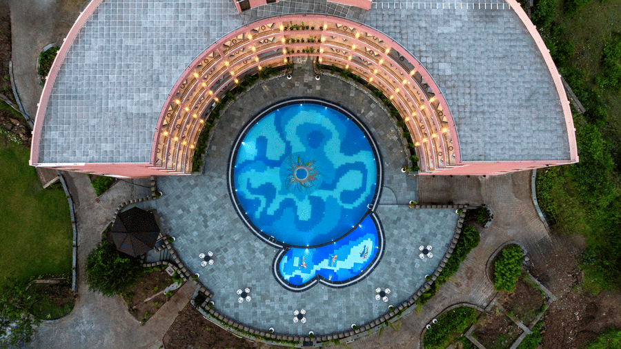 An aerial view of the Osian Valley Resort & Spa showing a central blue-tiled swimming pool partially surrounded by a building.