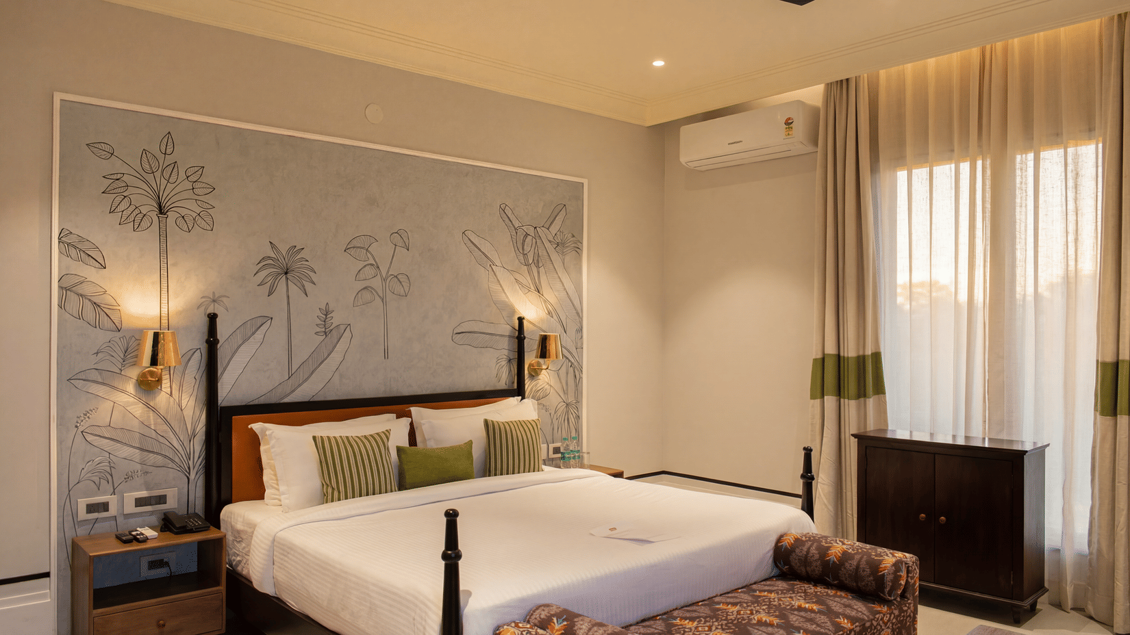 A bedroom area with a king size bed against a patterned wall, a dark wooden cabinet, and long curtains at The Sierra - By The Lake.