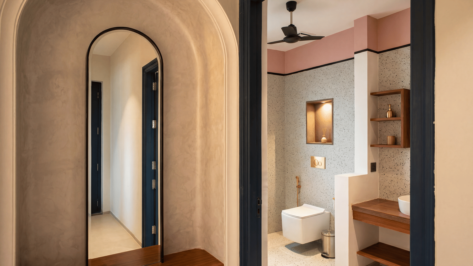 A dual view displaying an arched full-length mirror in a corridor, a wall-mounted toilet, and a sink vanity at The Sierra - By The Lake.