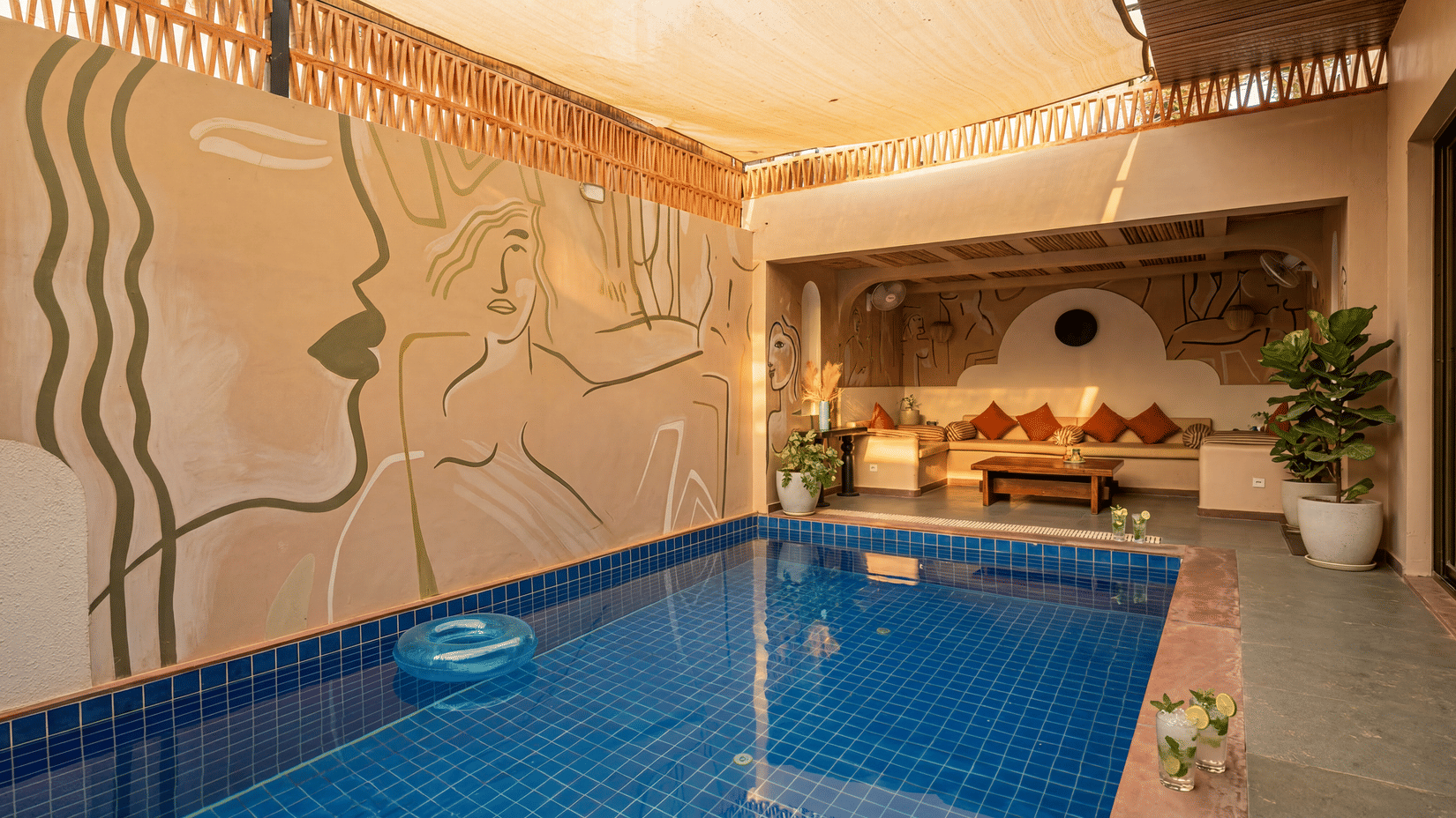 A swimming pool at The Sierra - By The Lake featuring a private plunge pool, a comfortable indoor seating alcove, and a decorative textured wall.
