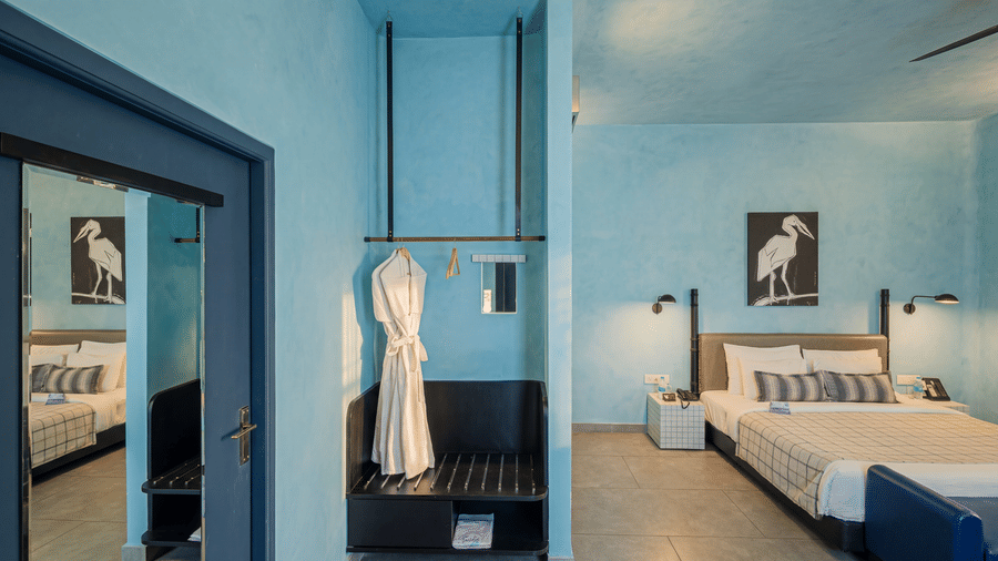 A spacious bedroom featuring a king size bed, bedside tables, artwork, dressing mirror, and bathrobe at The Sierra - By The Lake.