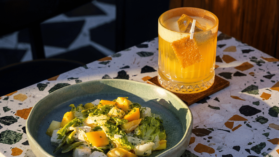 A bowl of food and a glass of juice placed on a patterned table at The Sierra - By The Lake.