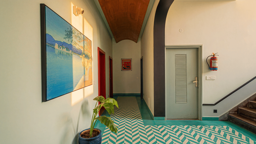 An indoor lobby with a chevron patterned tiled floor, a painting on the wall, a door, a staircase at The Sierra - By The Lake.
