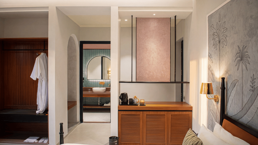 An interior view of a room with an open closet area, a wooden storage cabinet, and a doorway leading to a bathroom at The Sierra - By The Lake.