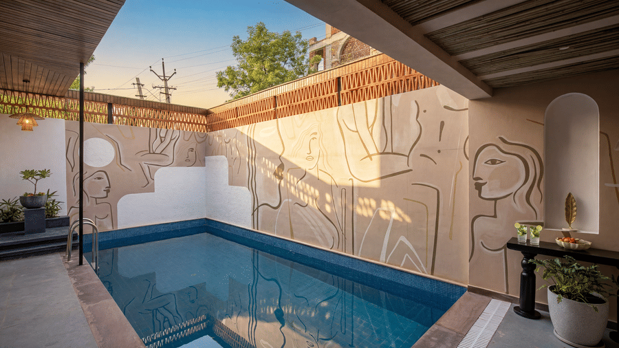 A swimming pool at The Sierra - By The Lake featuring a private swimming pool, a textured feature wall, and a wooden ceiling structure over a patio.
