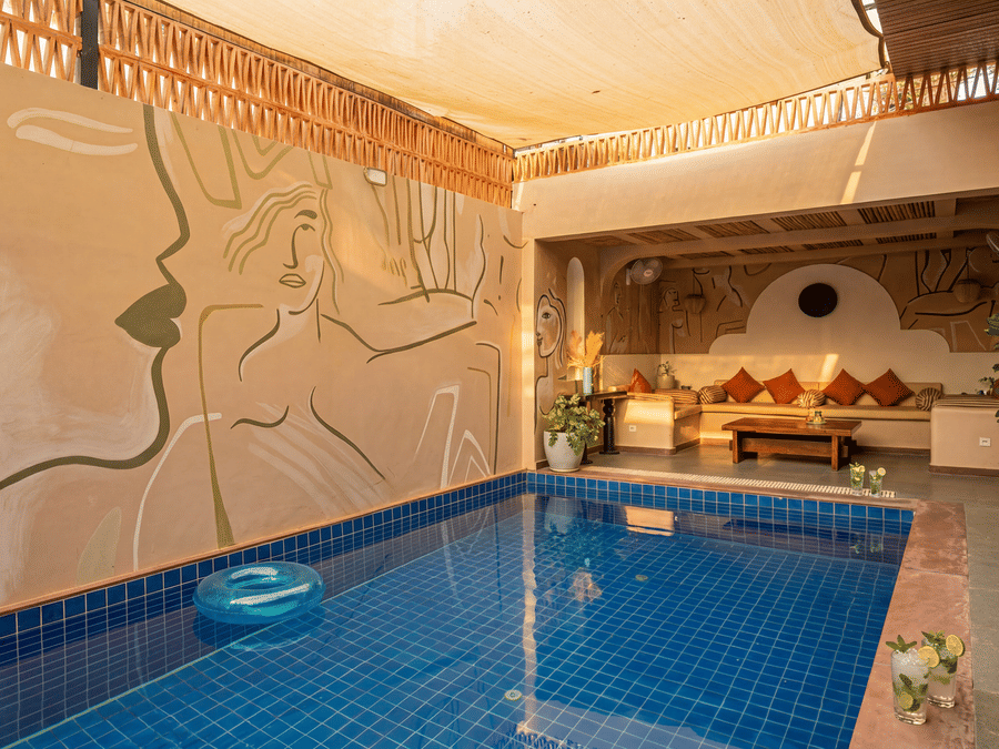 A swimming pool at The Sierra - By The Lake featuring a private plunge pool, a comfortable indoor seating alcove, and a decorative textured wall.