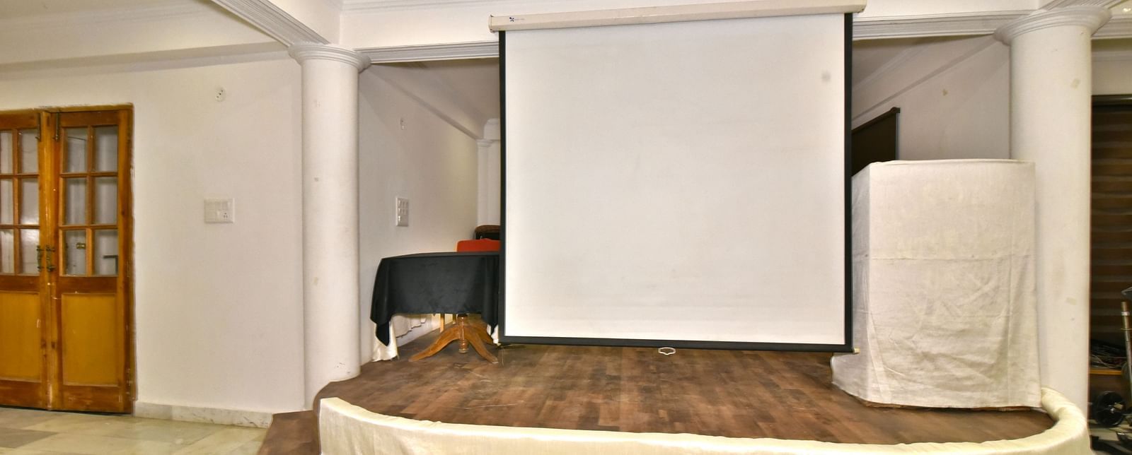 Event space featuring a white screen for seamless presentations and gatherings at DLS Hillcrest Resort, Shimla. 3541