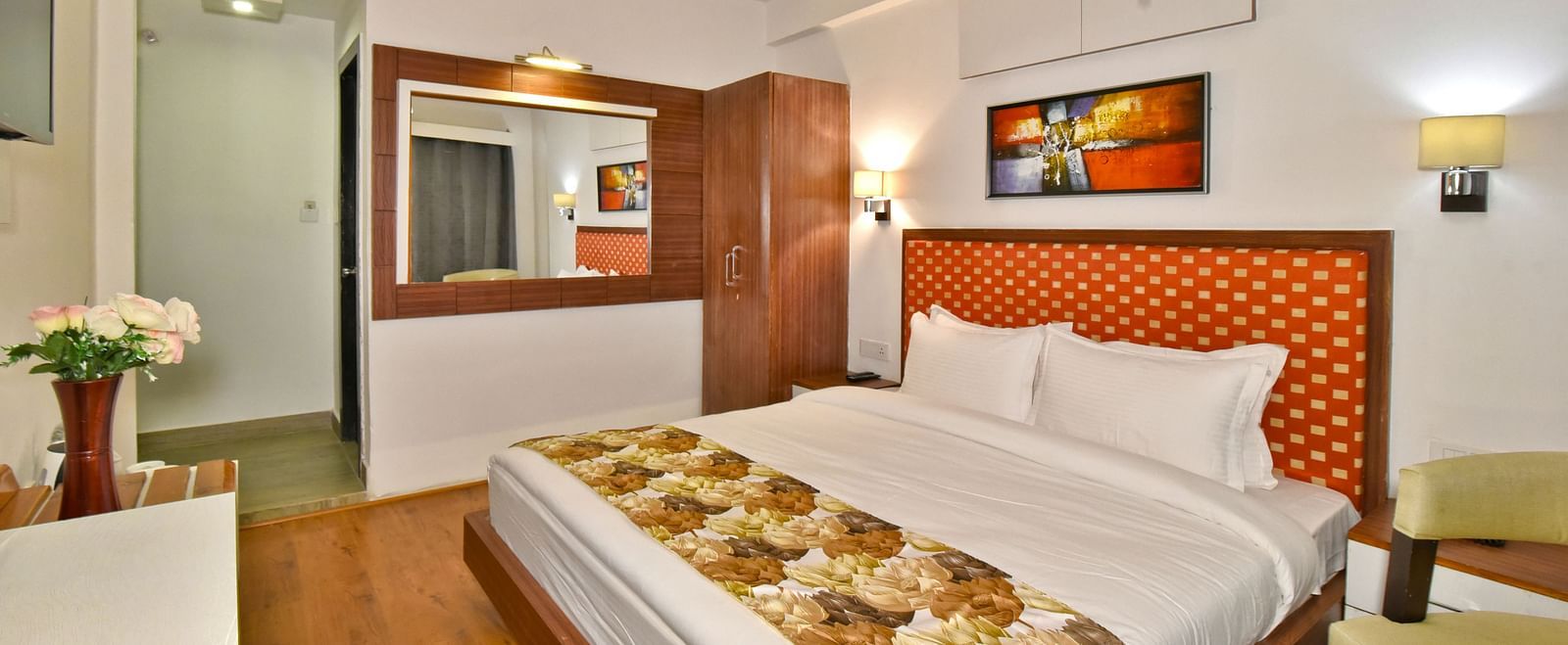 Bedroom with a portrait hanging on the wall above the bed at DLS Hillcrest Resort, Shimla.