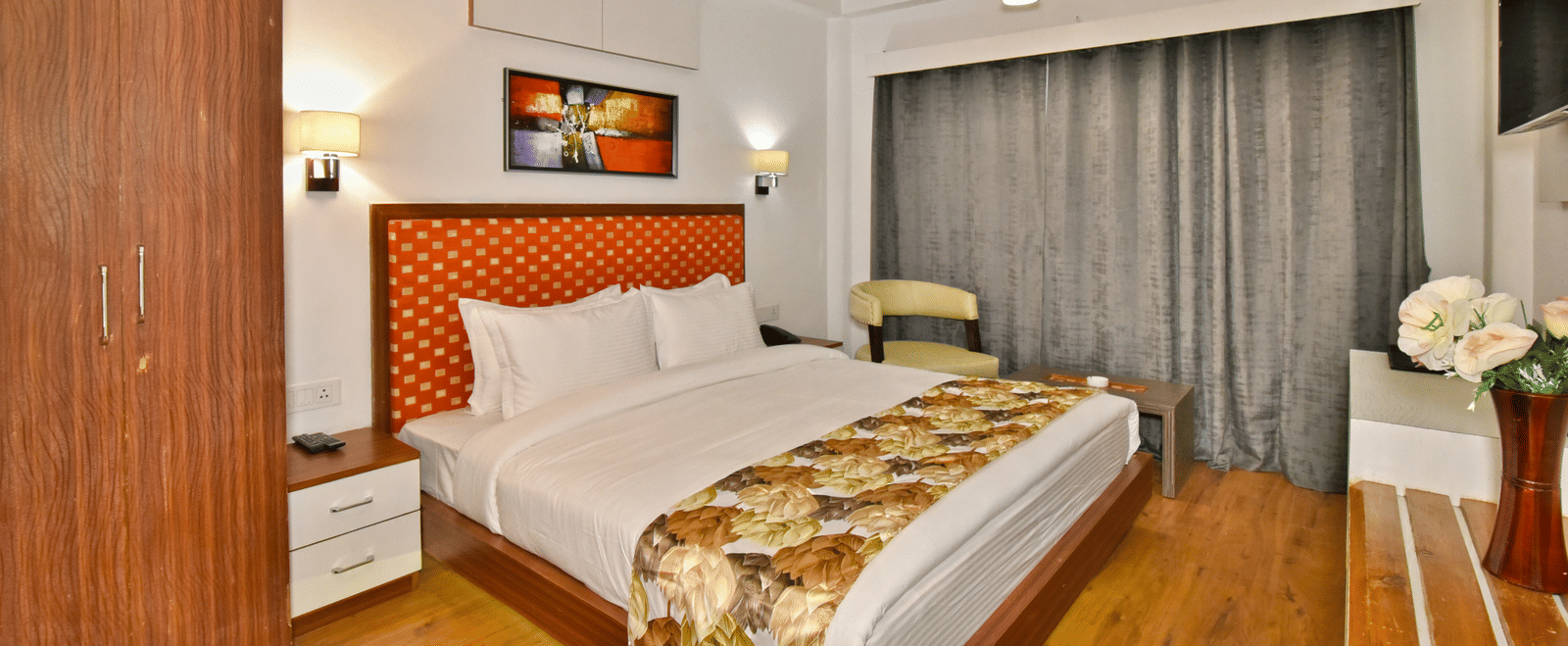 A bedroom with a wooden wardrobe nearby at DLS Hillcrest Resort, guaranteeing a restful experience in Mashobra, Shimla.