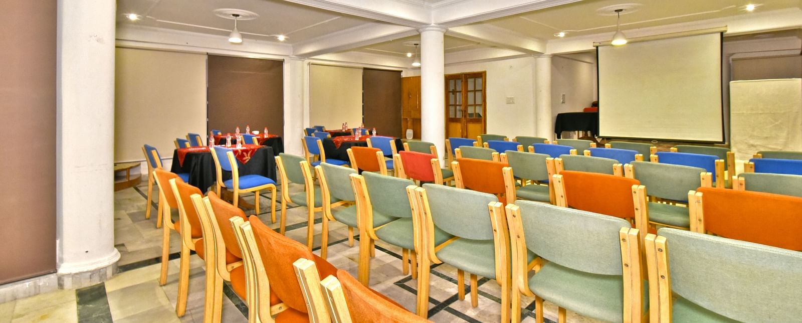 Back view of the event space with chairs arranged and a patterned ceiling at DLS Hillcrest Resort, Shimla.