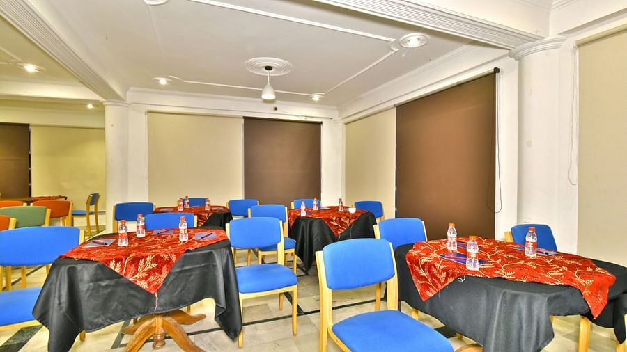Event space with multiple chairs and round tables, designed for hosting various events and gatherings at DLS Hillcrest Resort, Shimla.
