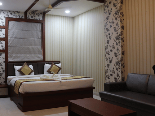 A stylish hotel room interior with contemporary design and warm lighting showcasing premium accommodations available through Varanasi hotel deals - Hotel Uday Palace.