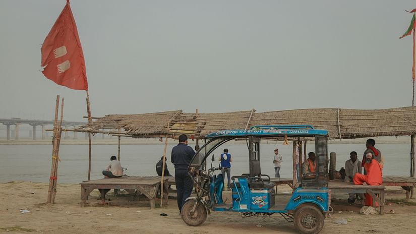 a group of people sitting inside a big open hut next to a beach in allahabad