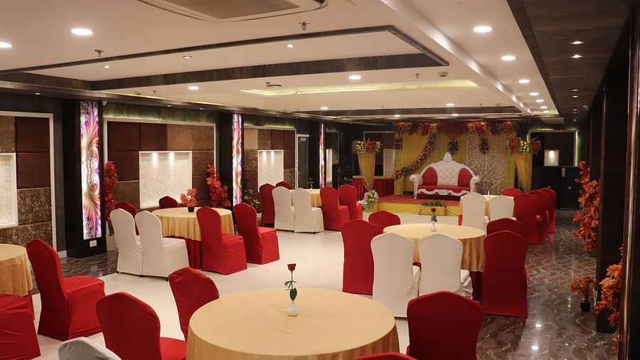 View from the end of the banquet hall, showcasing elegantly arranged tables and chairs facing the stage. A perfect setting at one of the banquet halls in Varanasi.