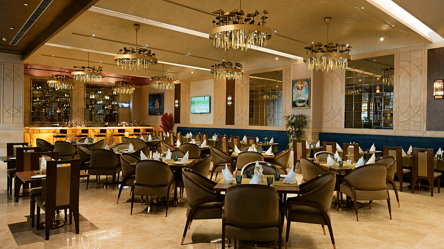 Another view of the dining space at The Gaurs Sarovar Premiere, showcasing the seating arrangement and overall layout of the restaurant.