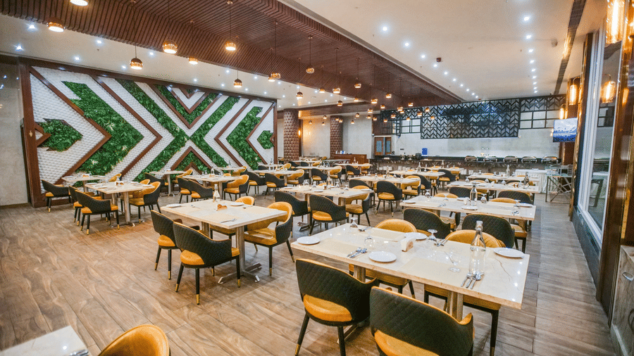 An expansive dining area featuring organised table settings and plush yellow and grey chairs - Leroy Grand, Yeshwanthpur