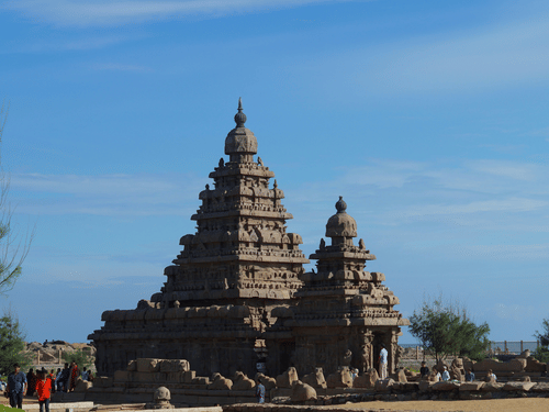 The Shore Temple against a bright blue sky with visitors walking around