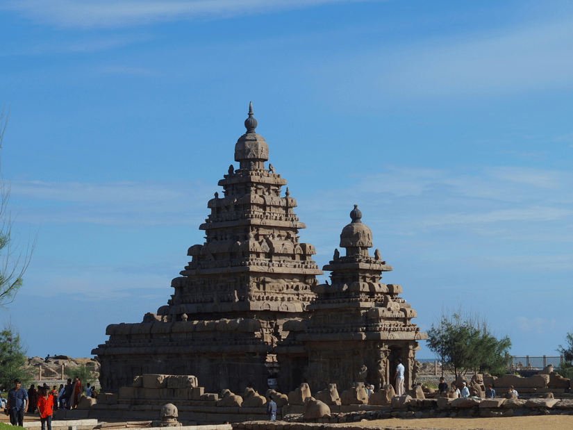 The Shore Temple against a bright blue sky with visitors walking around