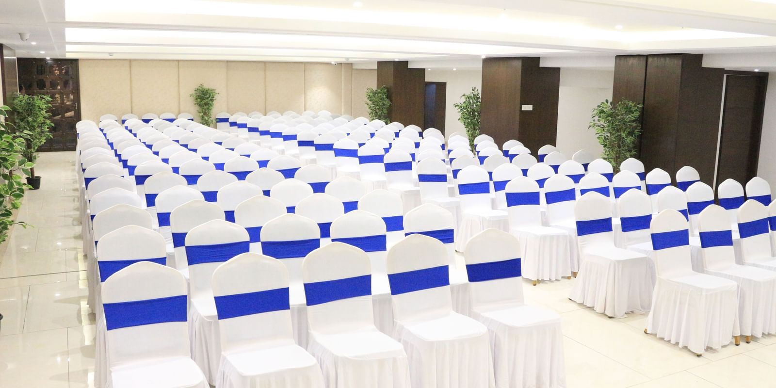 A banquet hall with neatly arranged chairs on both sides, creating a pathway in the middle at The Hamuse Hotel, Kodaikanal.