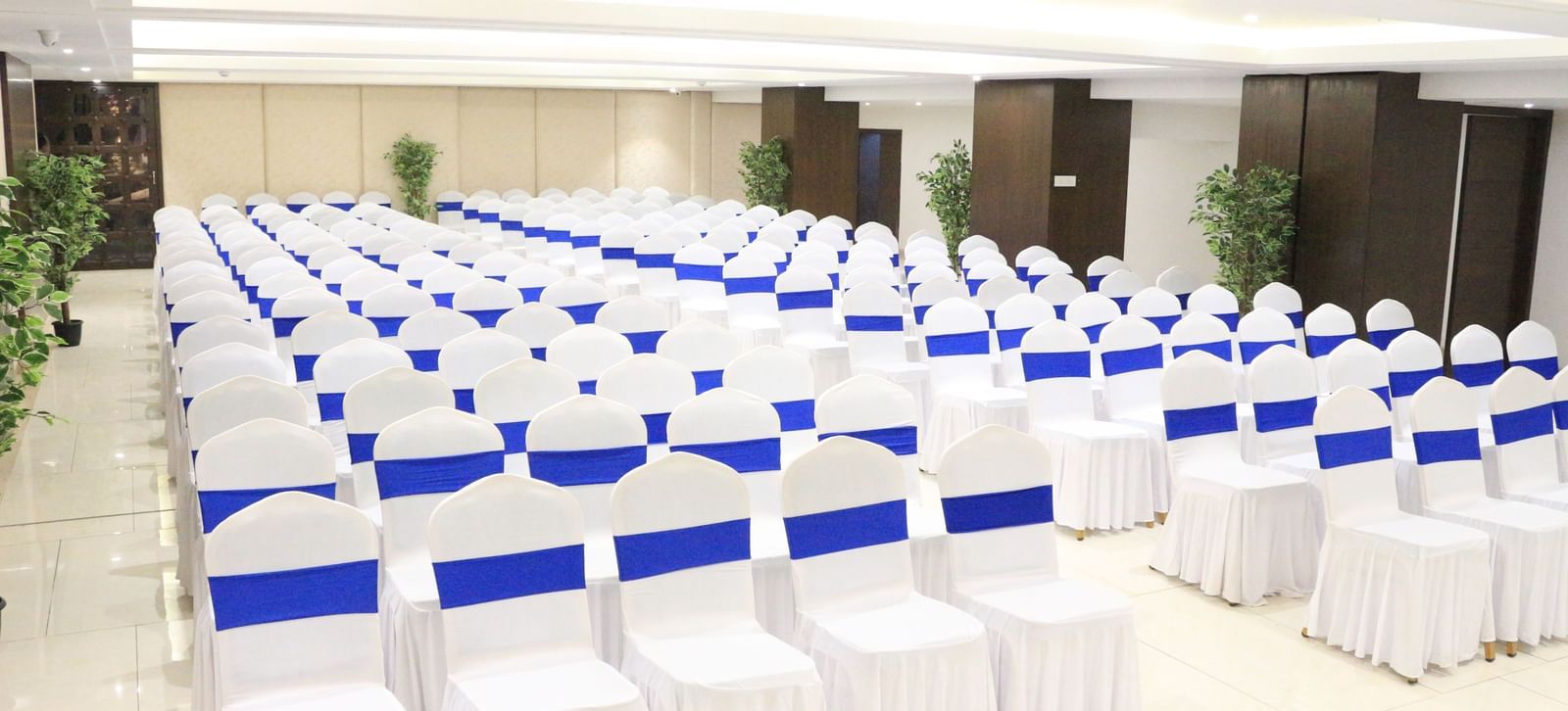 A banquet hall with neatly arranged chairs on both sides, creating a pathway in the middle at The Hamuse Hotel, Kodaikanal.