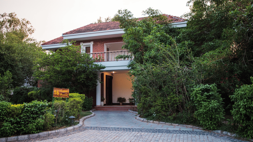 An overview of the Klub Karma Villas's exterior with trees covering both sides at Karma Lakelands