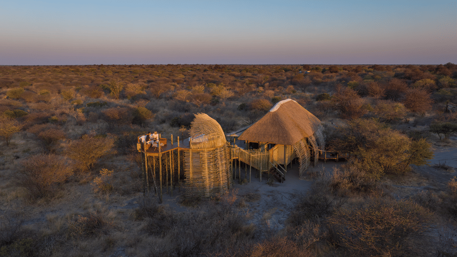 Aerial view of tented camp glowing at sunset in the Kalahari at Evolve Back resort