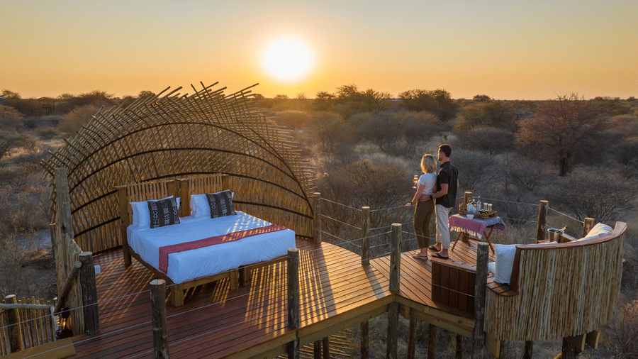 Couple on a starbed deck watching the Kalahari sunset at Evolve Back resort