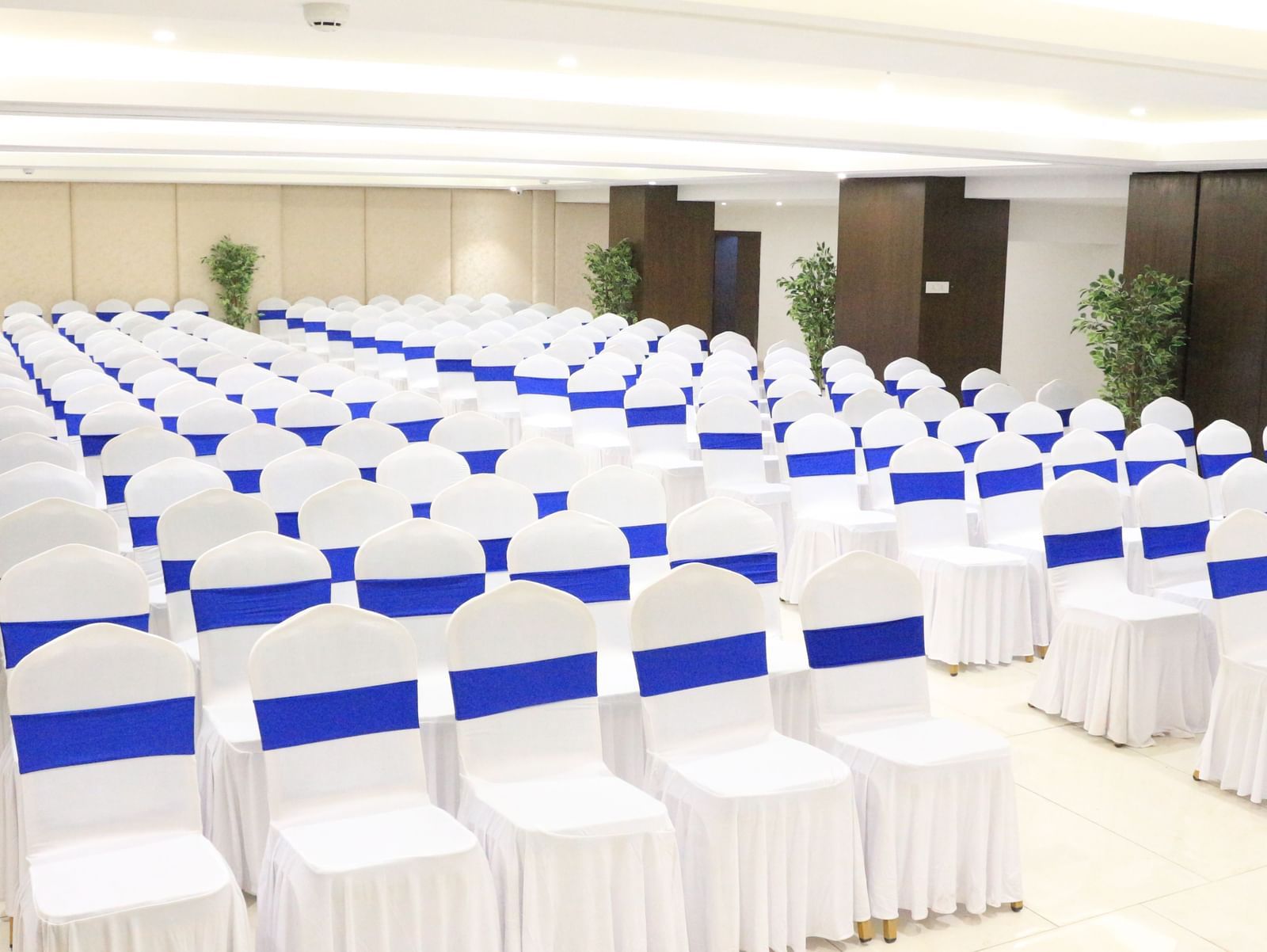 A banquet hall with neatly arranged chairs on both sides, creating a pathway in the middle at The Hamuse Hotel, Kodaikanal.