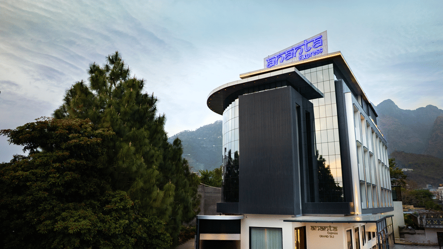 The modern multi-storey exterior of the hotel building with large glass windows during the day at Ananta Express, Katra.
