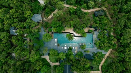 Aerial view of Hotel Sonar Bangla Joypur Forest, Bankura, showcasing its pool nestled amid lush, dense woodland surroundings.