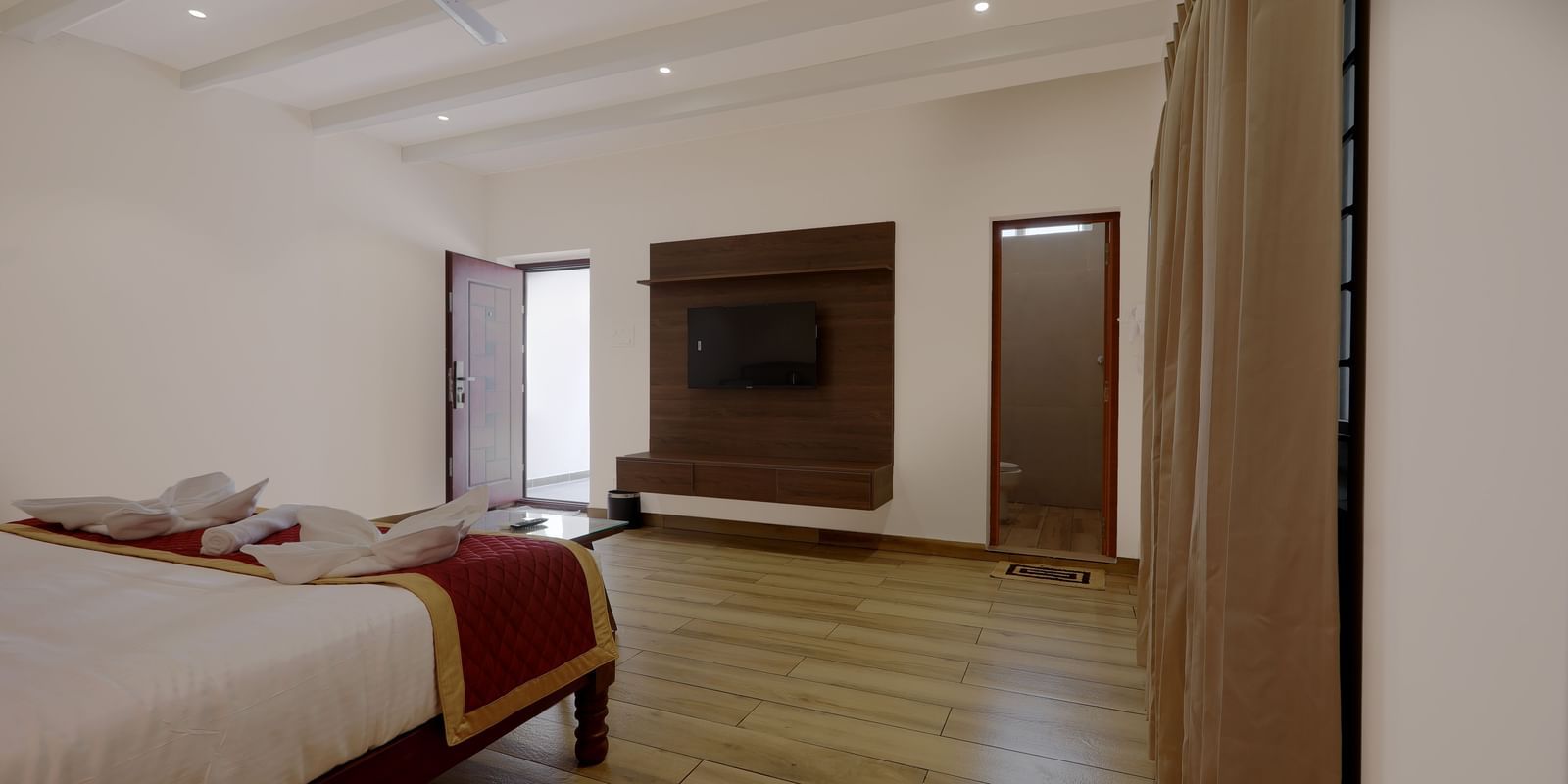 Corner view of the Terrace Cottage featuring a wall-mounted television placed opposite to the double bed at WOW Naturefull Resorts, Yercaud.