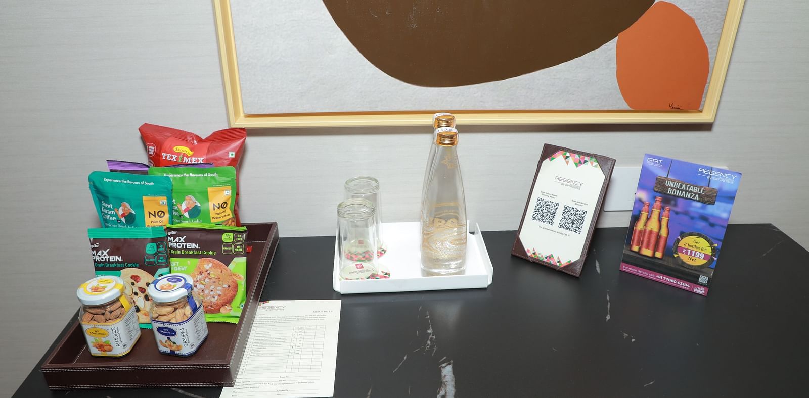 A table with a water bottle and snacks in our Regent Suites in Tuticorin - Regency Tuticorin by GRT Hotels