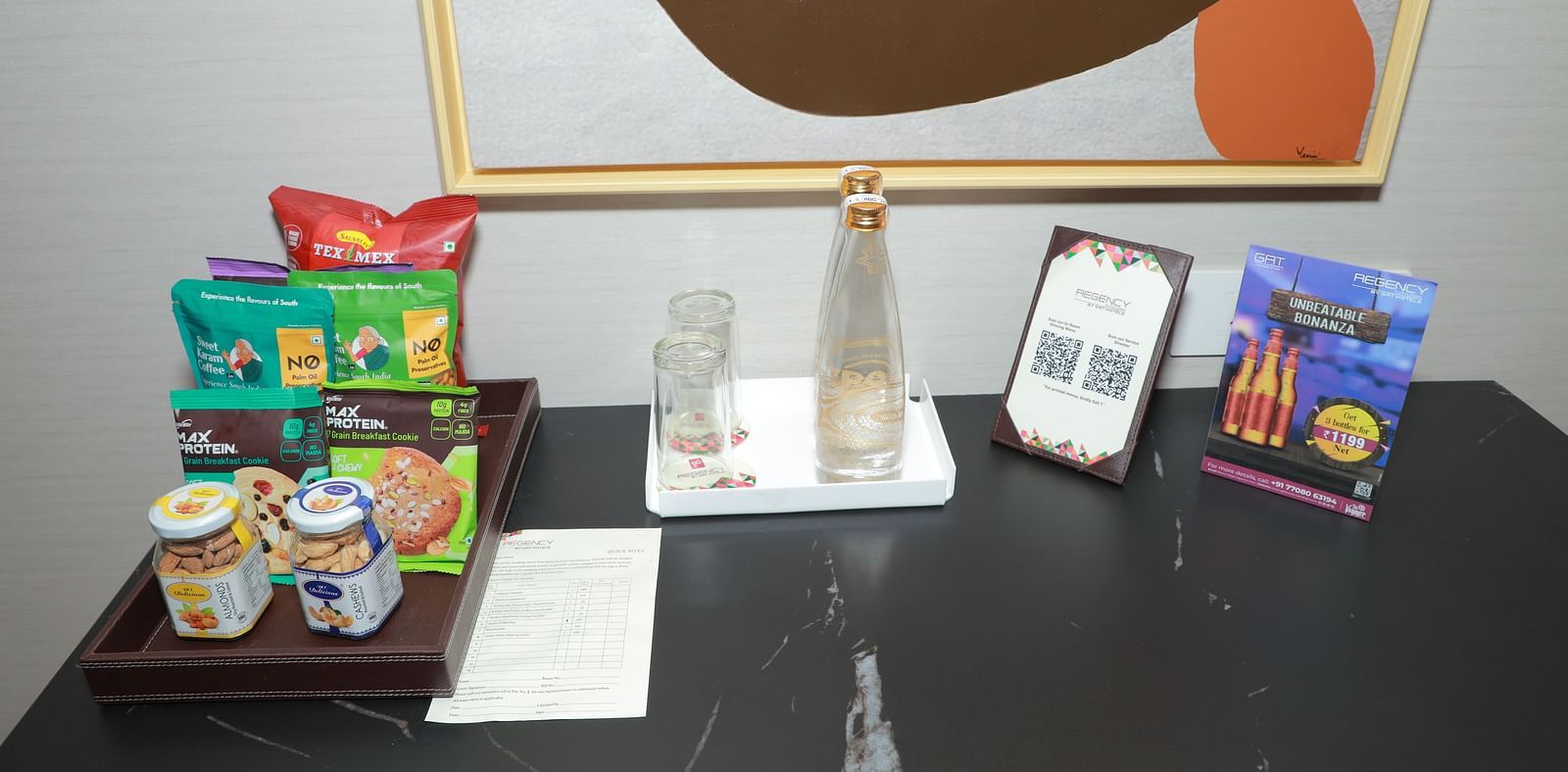 A table with a water bottle and snacks in our Regent Suites in Tuticorin - Regency Tuticorin by GRT Hotels