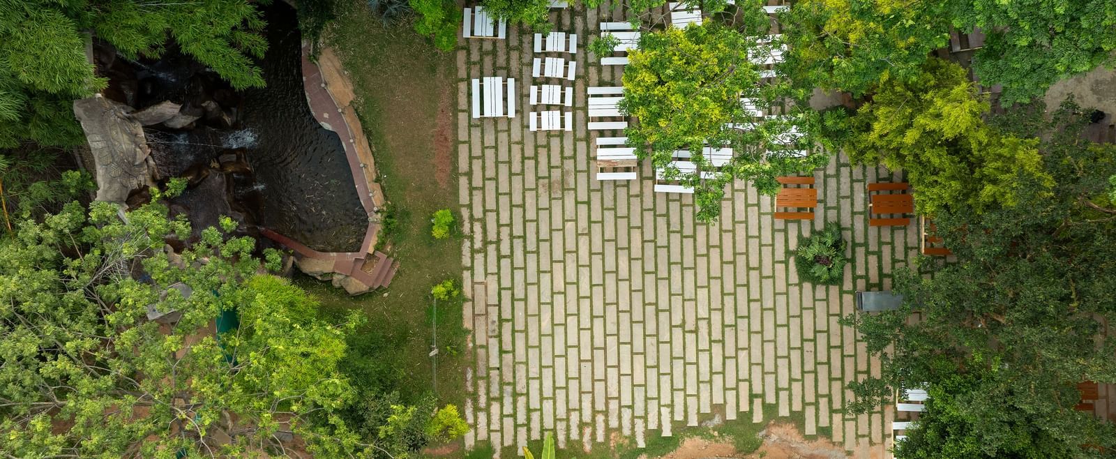 A close-up view of a natural bamboo fence partially obscured by lush green foliage | RD's Nature Retreat, Bangalore