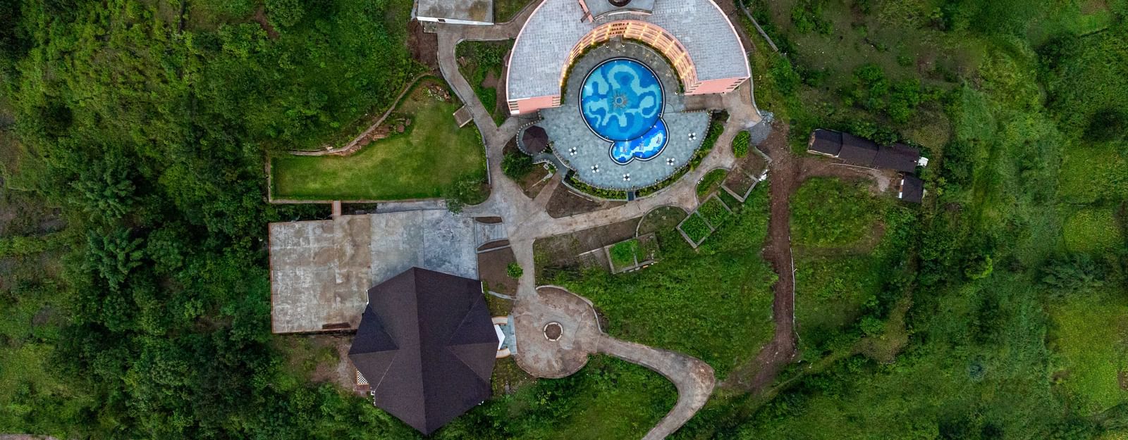 Aerial view of the Osian Valley Resort & Spa, showing the main buildings, surrounding landscape, and a swimming pool.