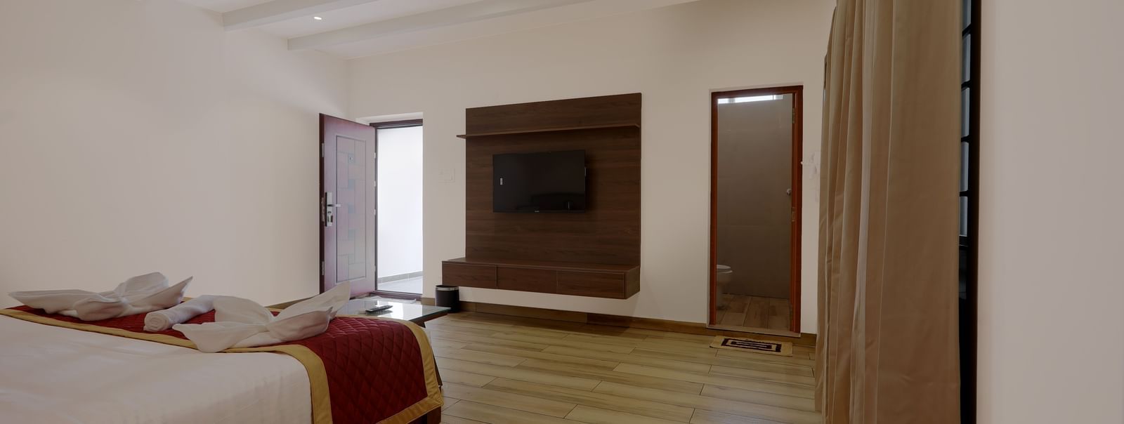 Corner view of the Terrace Cottage featuring a wall-mounted television placed opposite to the double bed at WOW Naturefull Resorts, Yercaud.