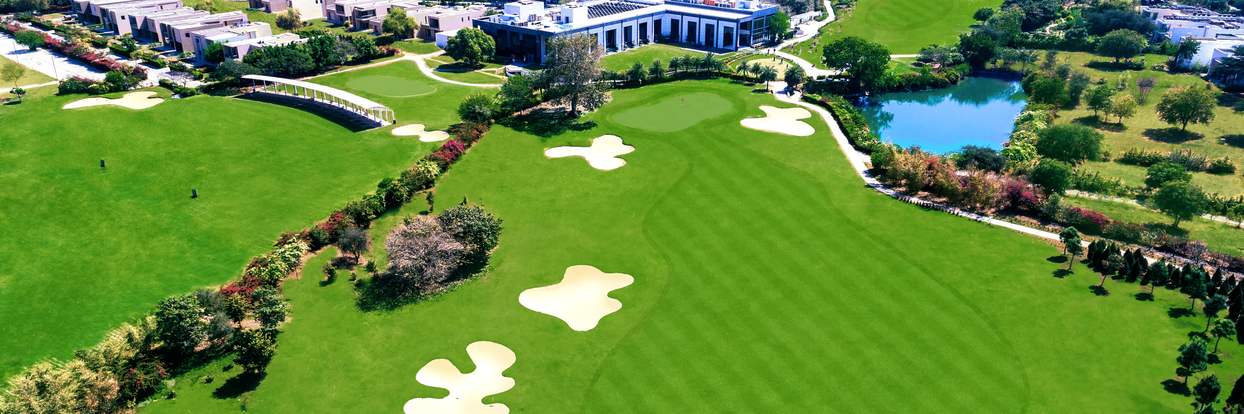 An aerial view of Karma Lakelands with many building and golf course in view.
