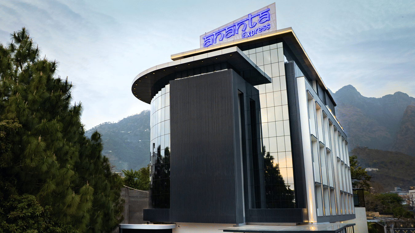 The modern multi-storey exterior of the hotel building with large glass windows during the day at Ananta Express, Katra.