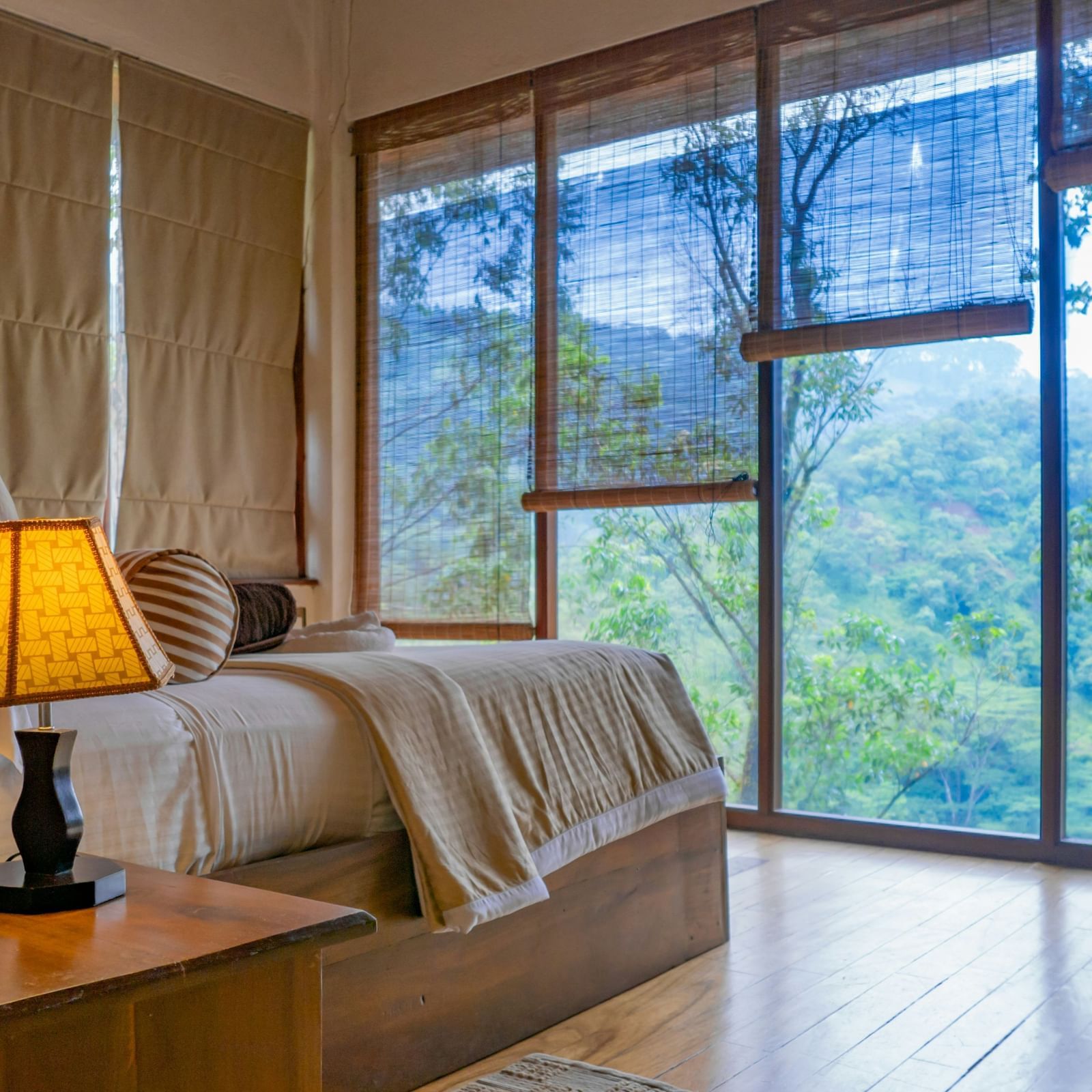 Balcony or terrace area with a wooden roof, railing, and lush green surroundings.
