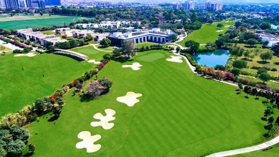 An aerial view of Karma Lakelands with many building and golf course in view.