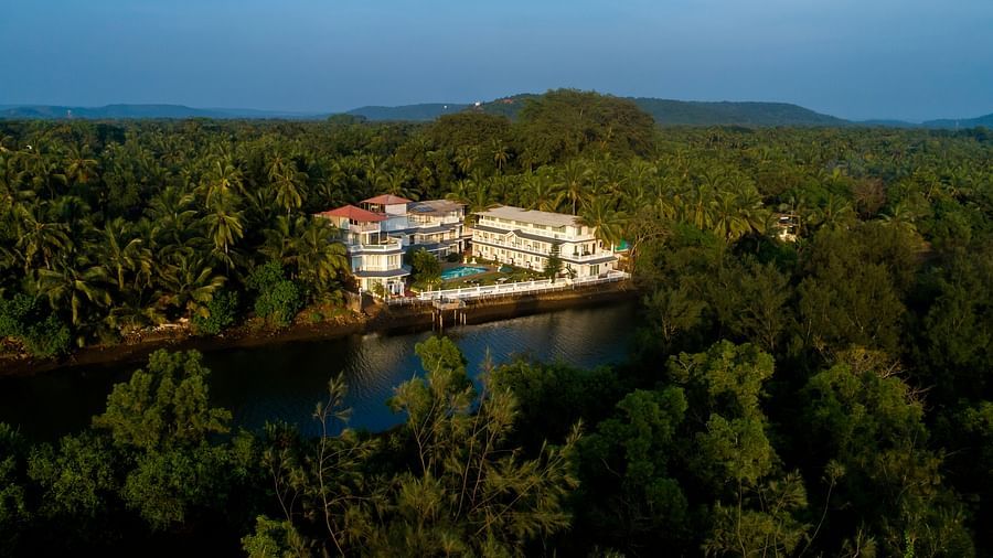 The hotel is surrounded by thick vegetation - Stone Wood Riverfront Resort, Siolim