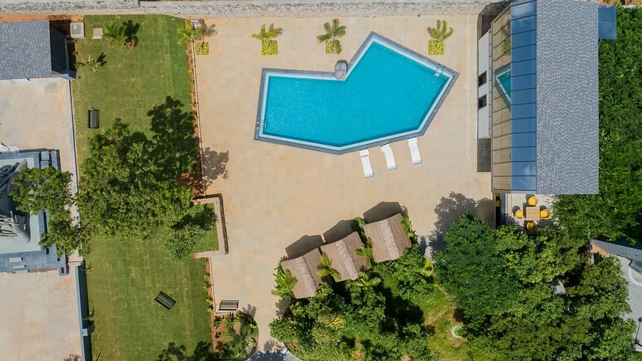 aerial view image of the main swimming pool with lush greenery all around - Darza Resorts