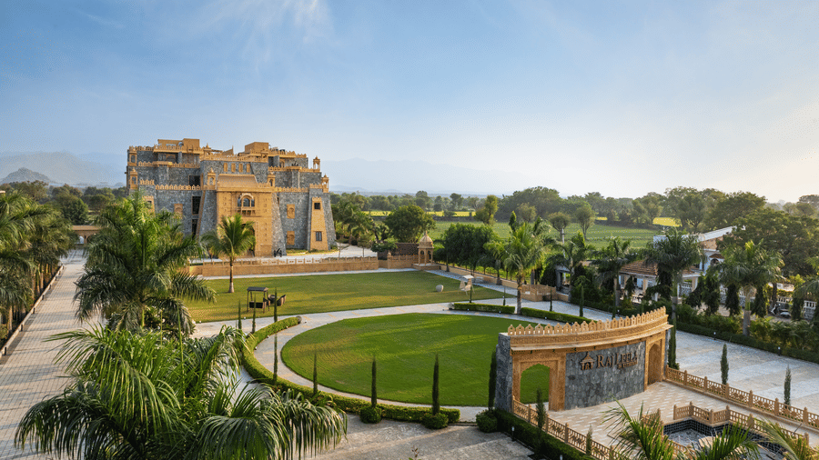 An aerial view of the landscaped gardens, circular walkways, and facade of EsthereaRaj Leela, Ranakpur.